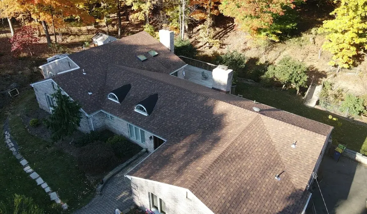 A clay tile roof on a New Jersey home with valley flashing and ridge tiles being inspected for cracked tiles