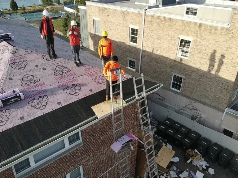 Crew finishing a shingle roof